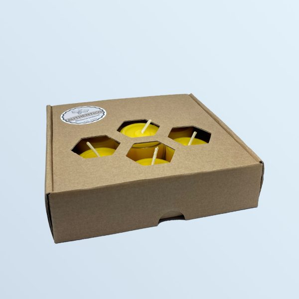 geschlossene Schachtel mit sieben handgegossenen Teelichtern aus Bienenwachs. Durch eine Wabenstanzung sind einzelne Teelichter zu sehen und können ertastet werden